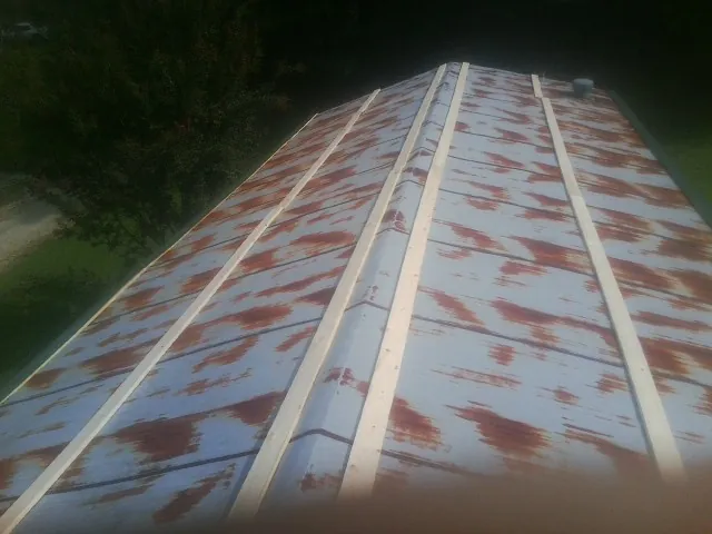 Rusted metal roof panels with new wood purlins before replacement — Storm Damage Roof Repair in Harsens Island by Roofing Brothers