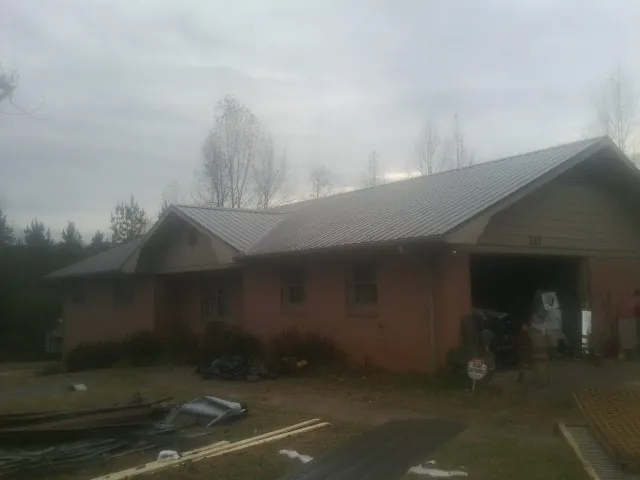 Gray metal roof on a stucco house with an attached garage in Harsens Island