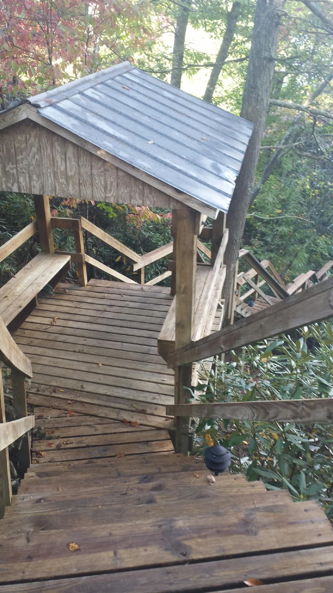 Metal roofed shelter over wooden steps on a wooded walkway — Skylight Repair & Installation work by our crew in Harsens Island
