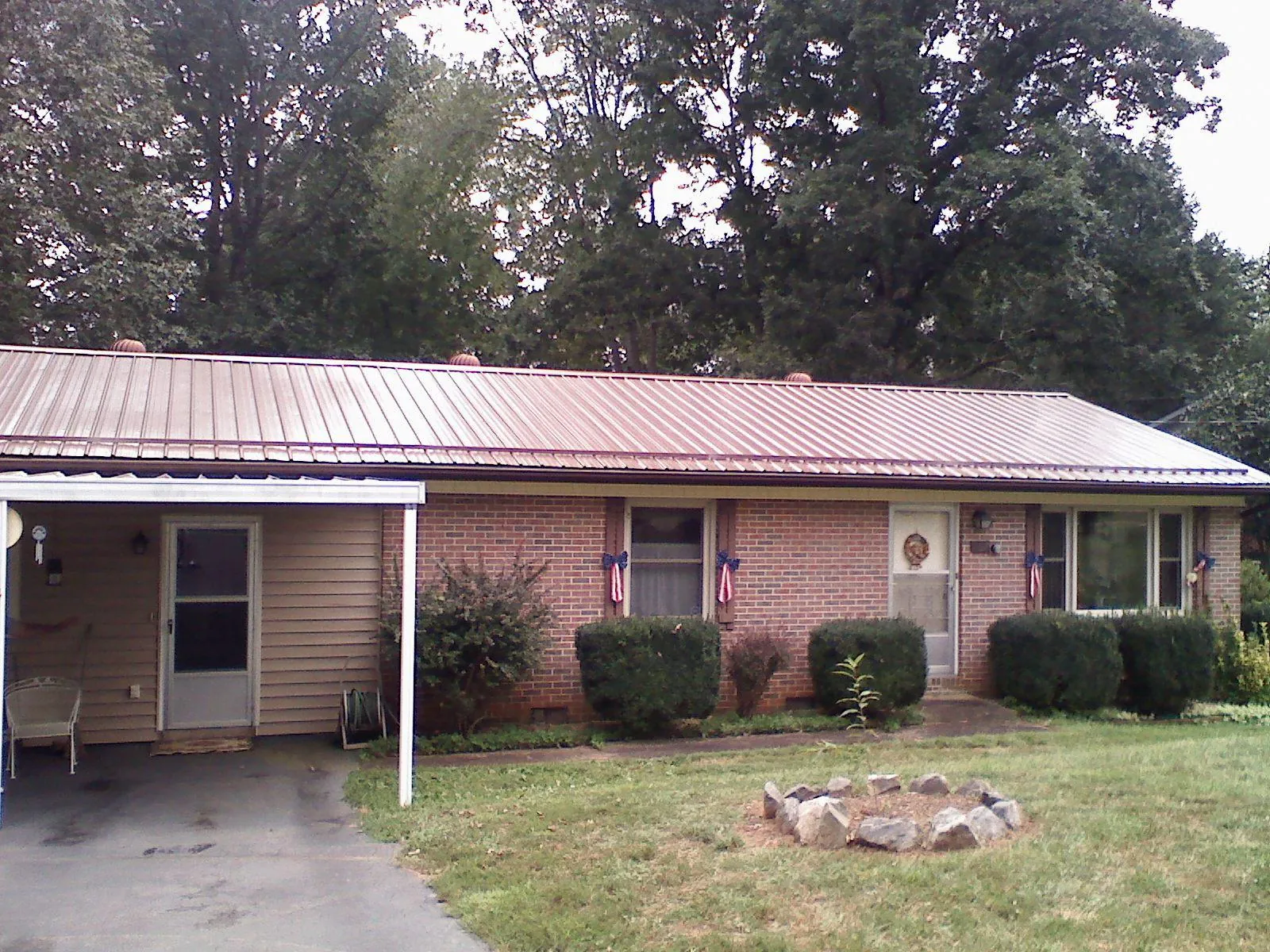 Bronze metal roof and carport on a brick ranch home — Roof Repair work by our crew in Harsens Island